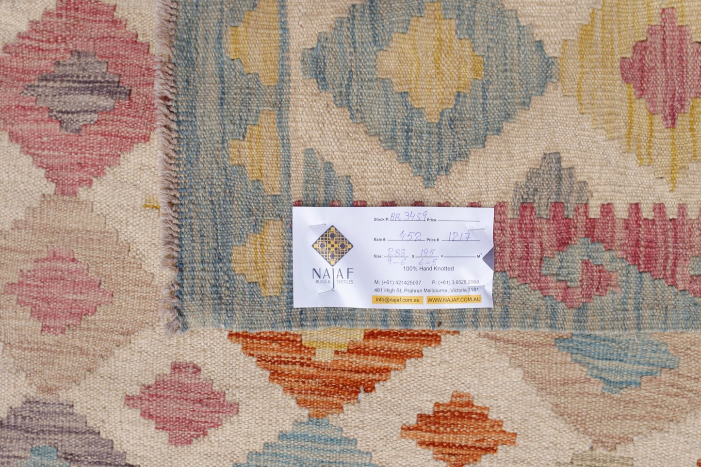 Handwoven Afghan Maimana Kilim rug featuring a geometric pattern in muted earth tones.