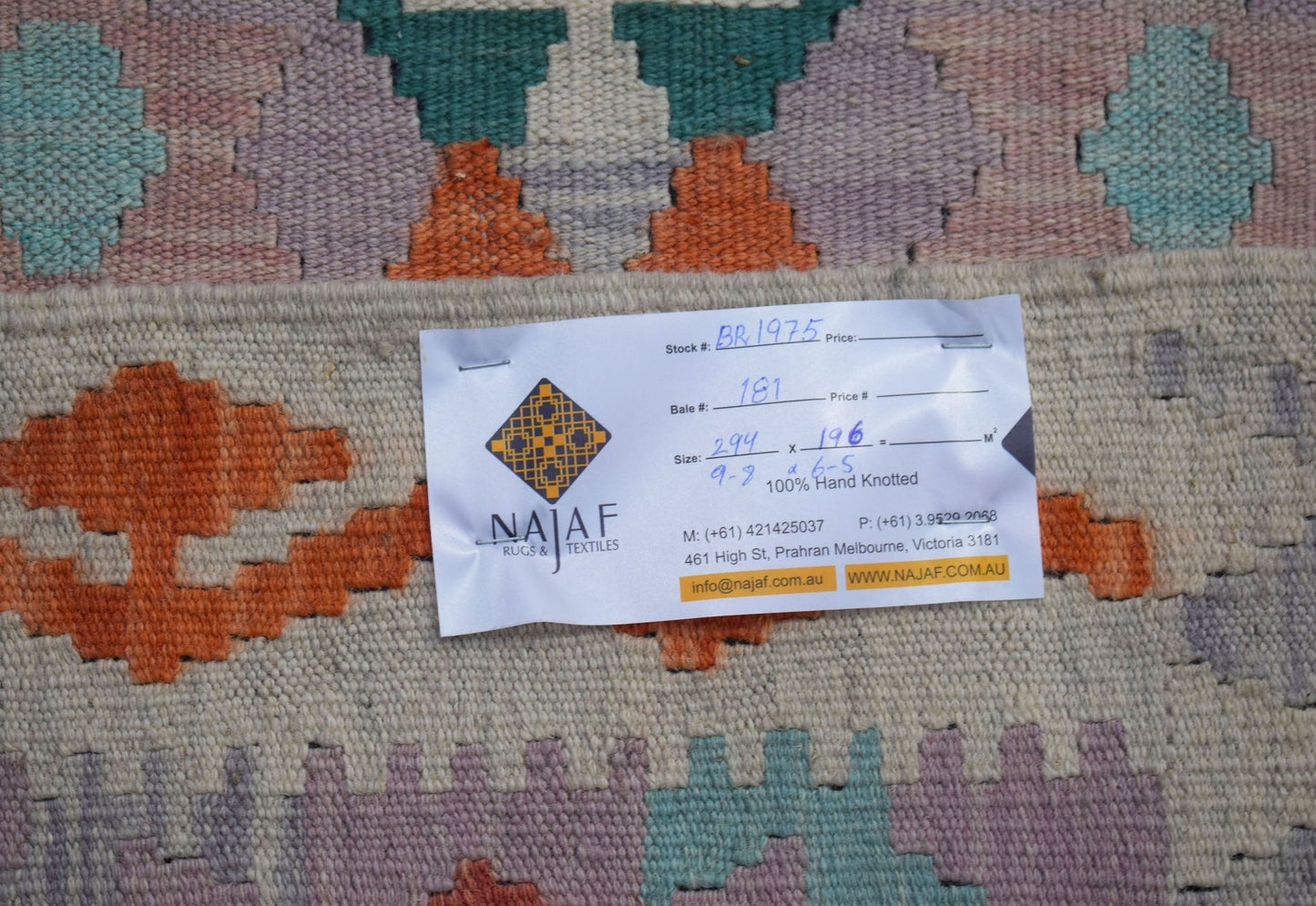 A handwoven Afghan Maimana kilim featuring a geometric pattern in orange, teal, and purple tones.