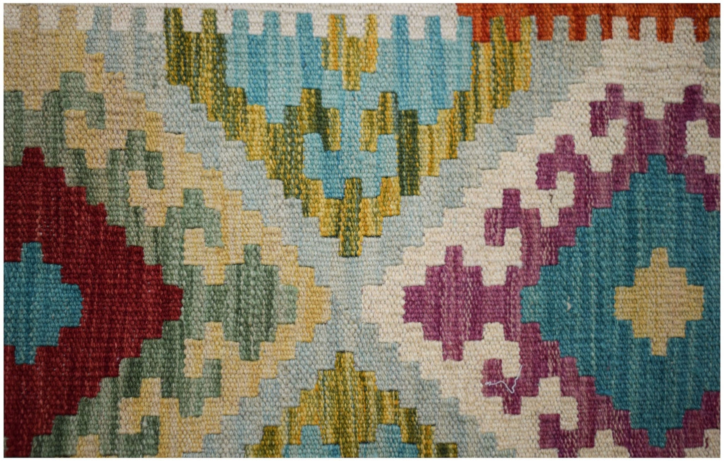Handwoven Afghan Maimana kilim featuring a vibrant geometric pattern in wool.
