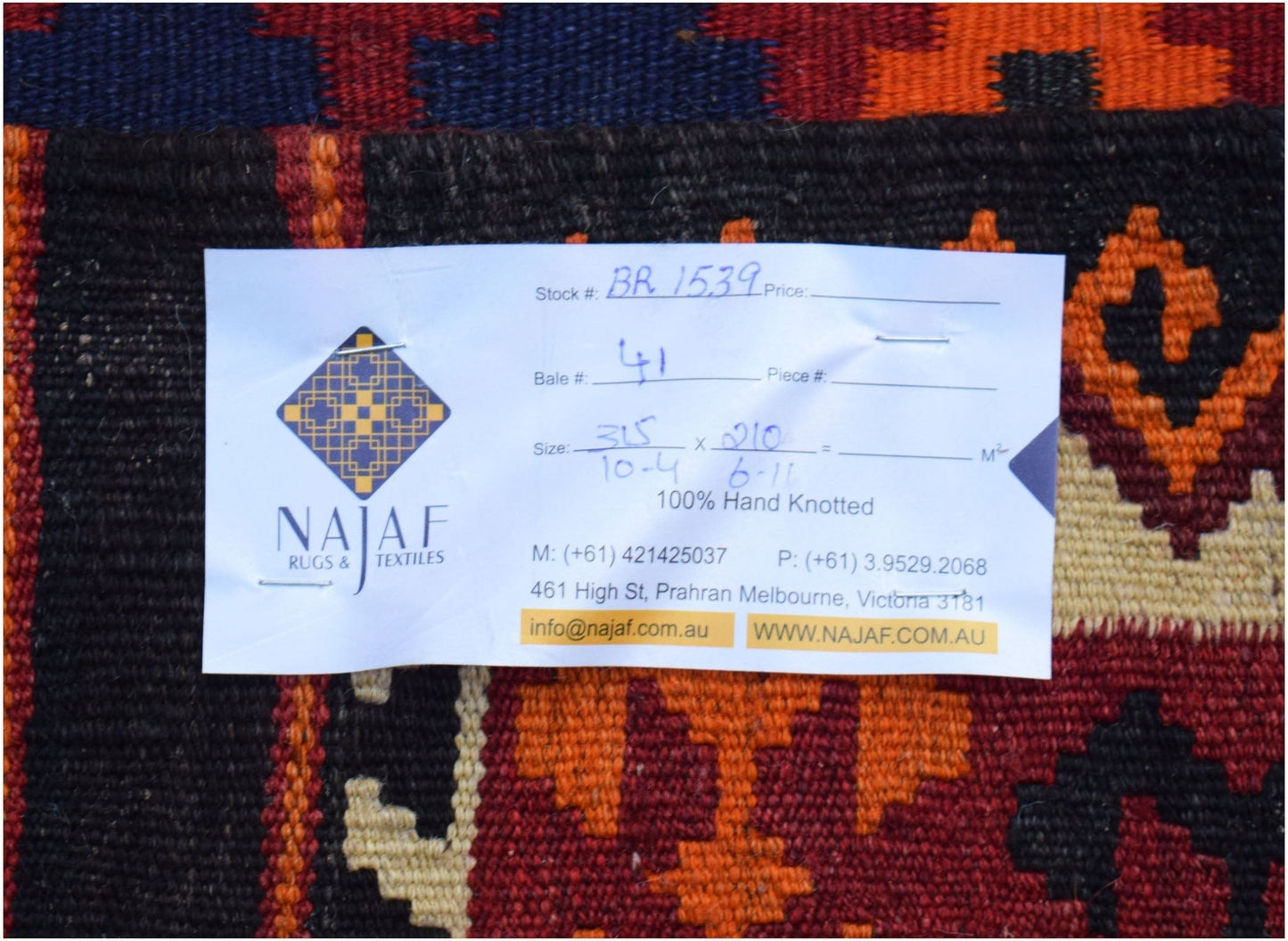 A handmade Afghan Maimana Kilim featuring a geometric pattern in red, orange, and dark blue.