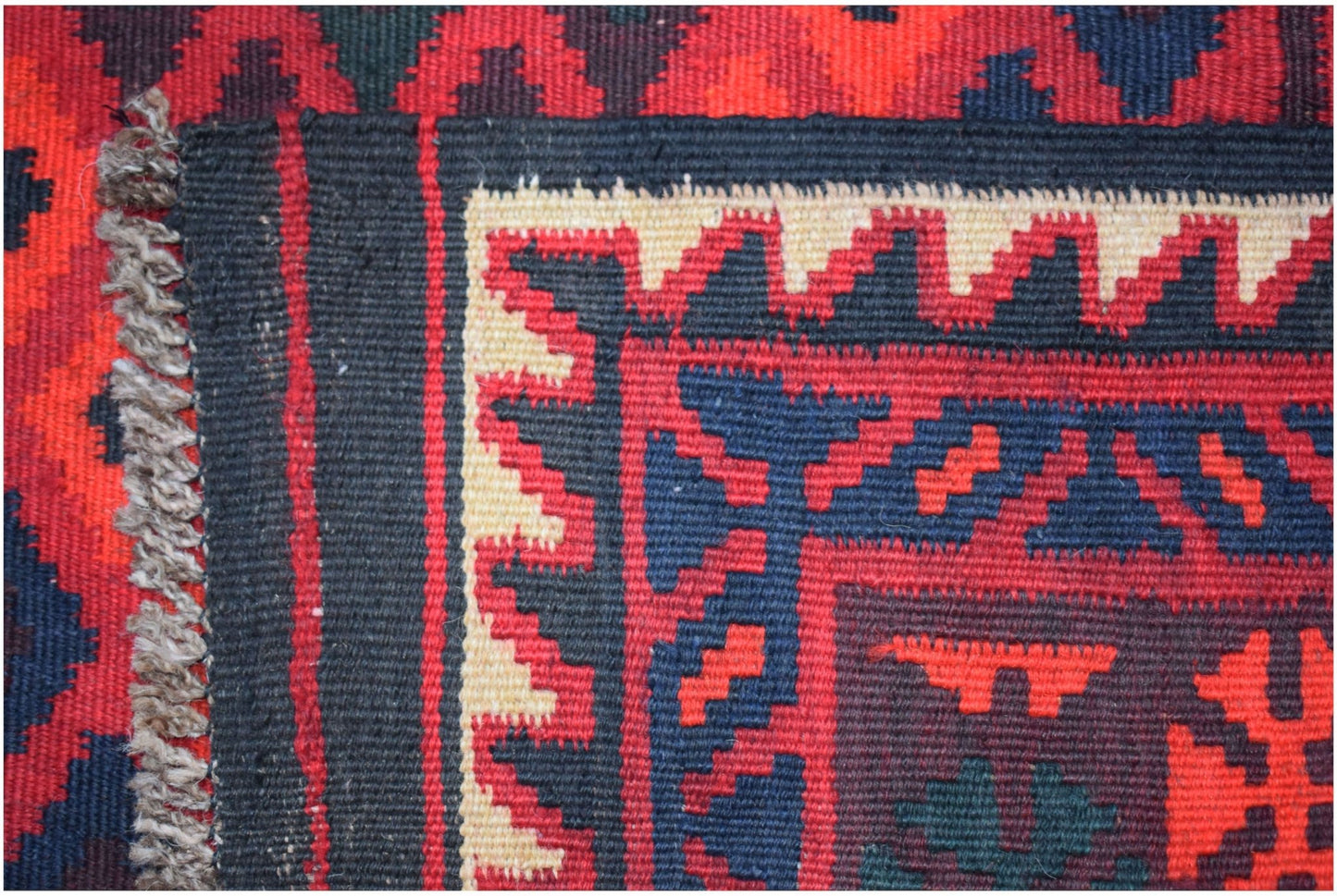 Handwoven Afghan Maimana kilim runner featuring geometric patterns in red, blue, and cream wool.
