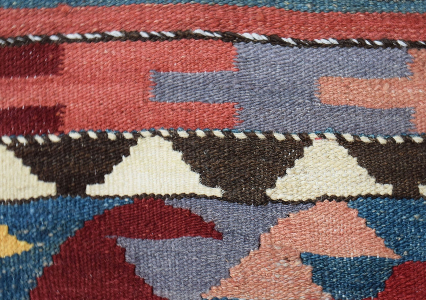 A close-up of a handwoven Afghan Maimana kilim runner featuring geometric patterns and wool texture.