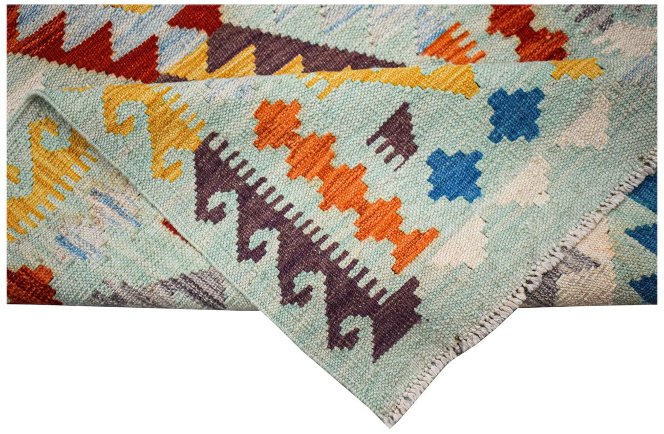 A handwoven Afghan Maimana Kilim runner featuring geometric patterns in vibrant wool colors.