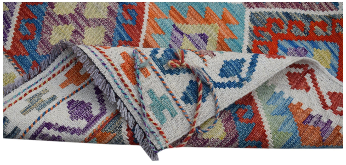 A handwoven Afghan Maimana kilim runner featuring vibrant geometric patterns in wool.