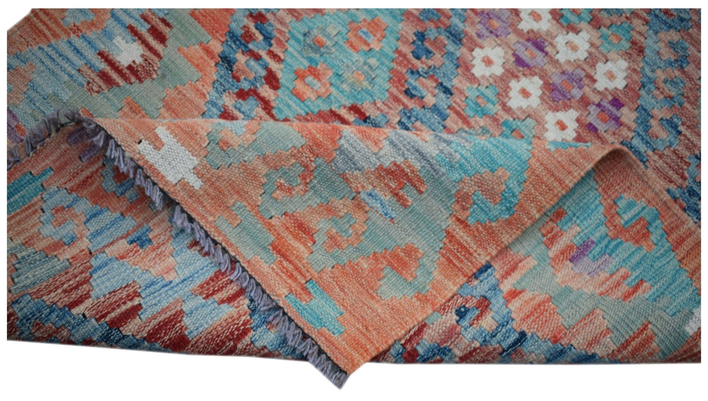 A handwoven Afghan Maimana wool kilim runner featuring a geometric pattern in blue and orange.