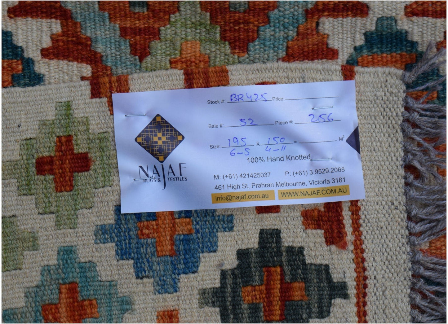 An Afghan Maimana Kilim rug featuring a geometric pattern in orange, blue, and green wool.