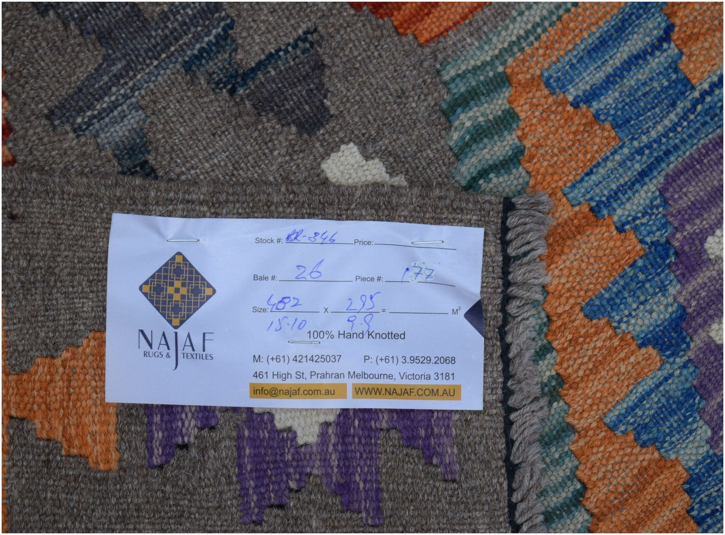 A handwoven Afghan Maimana kilim rug featuring a geometric pattern in orange, blue, and purple.