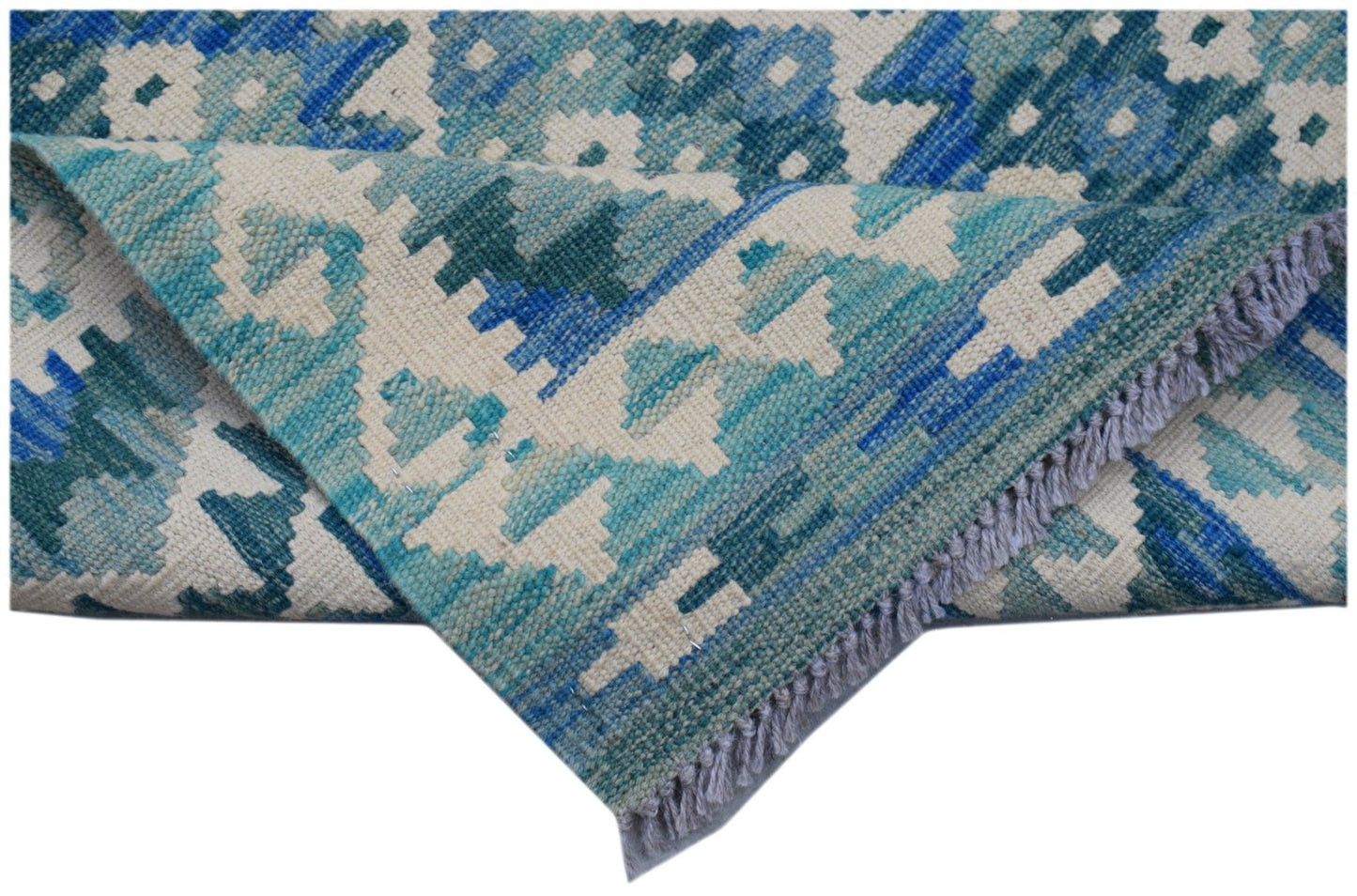 A handmade Afghan Maimana kilim runner featuring a geometric pattern in shades of blue and cream.
