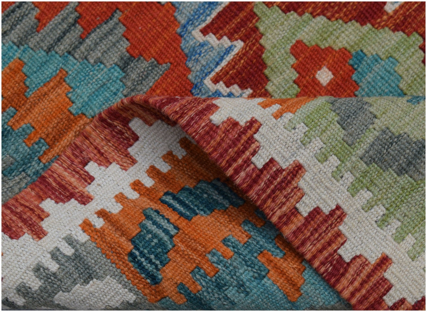 A handwoven Afghan Maimana kilim runner featuring a vibrant geometric pattern in wool.