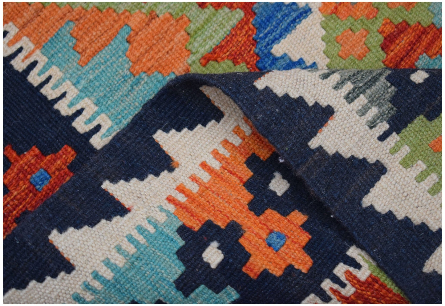 A handmade Afghan Maimana kilim runner featuring a vibrant geometric pattern in wool.
