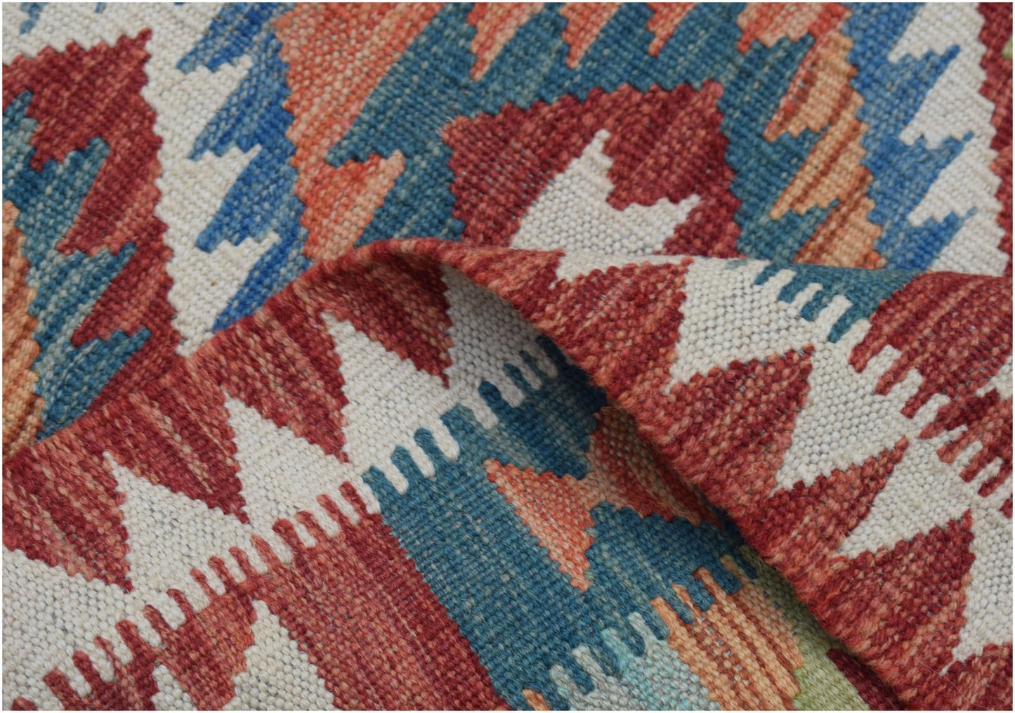 A handmade Afghan Maimana wool kilim runner featuring a geometric pattern in red, blue, and cream.