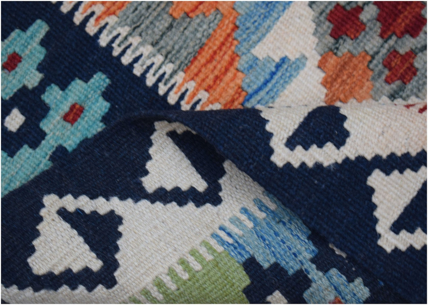 A handmade Afghan Maimana kilim runner featuring a geometric pattern in blue, orange, and cream.