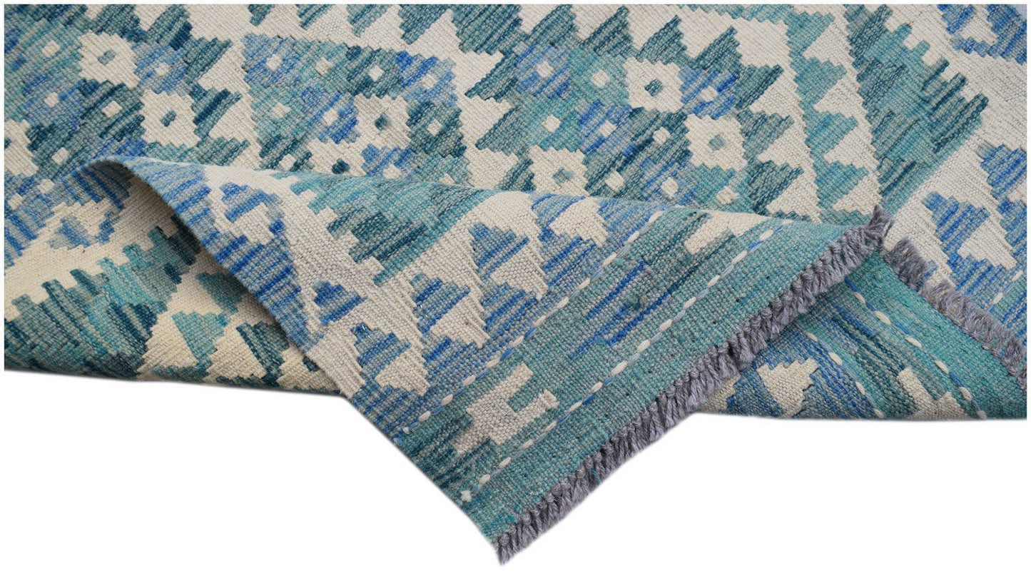 A handmade Afghan Maimana wool runner featuring a blue and cream geometric pattern.
