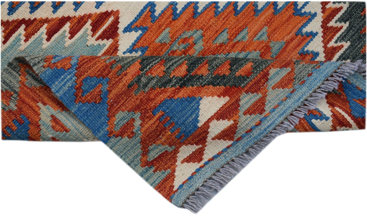 A handwoven Afghan Maimana Kilim runner featuring geometric patterns in orange, blue, and cream.