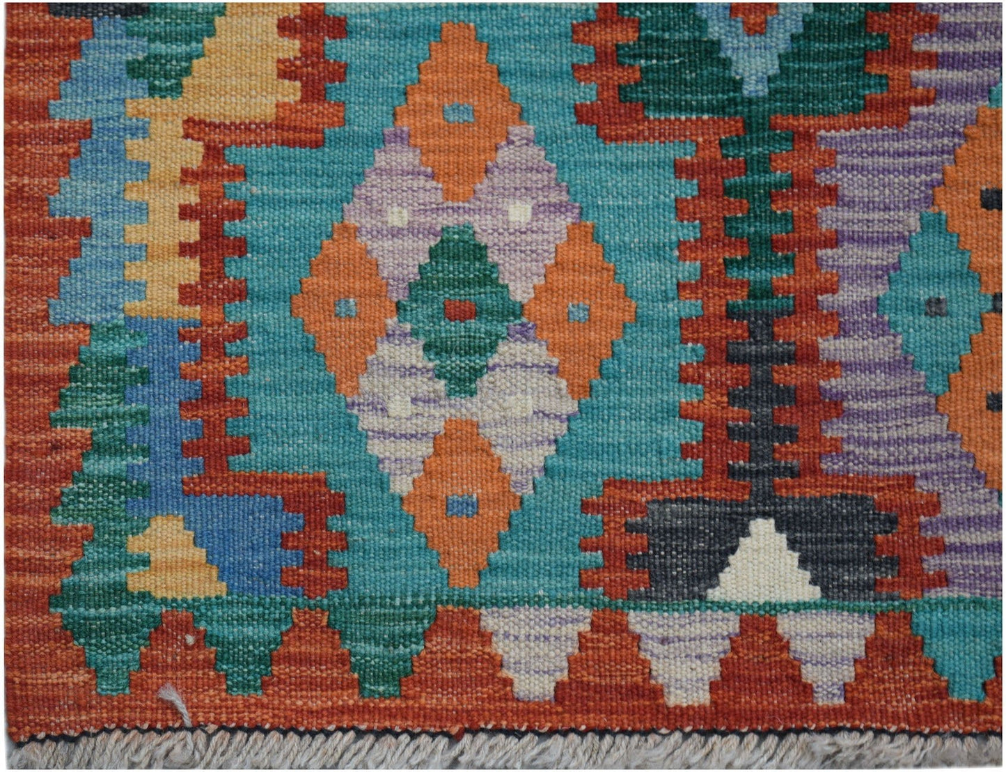 Handwoven Afghan Maimana kilim runner featuring a vibrant geometric pattern in wool.