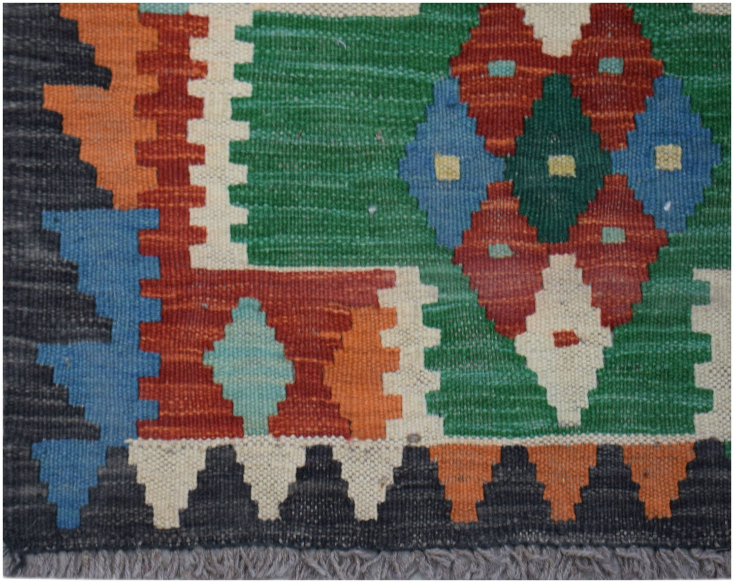 Handwoven Afghan Maimana wool runner featuring a vibrant geometric pattern in multi-colored hues.