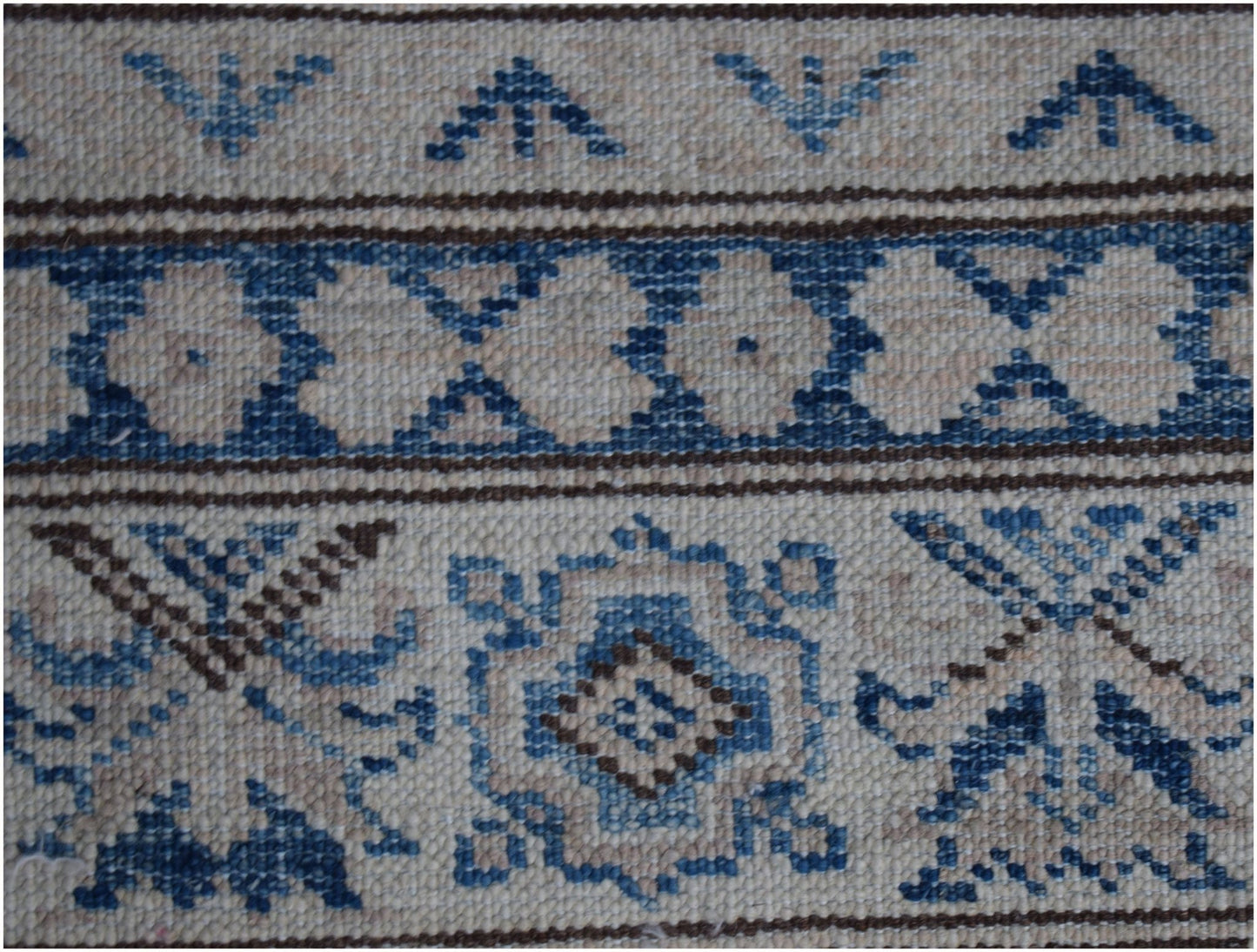 A close-up of an Afghan Super Kazakh runner featuring traditional blue and beige geometric motifs.