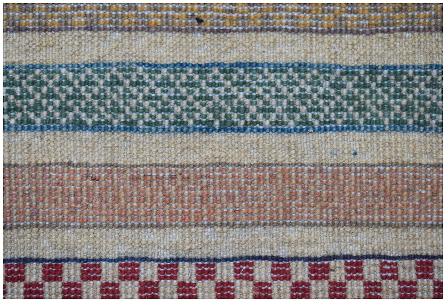 A handmade Afghan runner featuring horizontal stripes of textured wool in green, orange, and red.