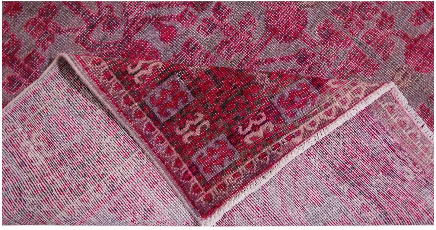 An antique handwoven Chinese Khotan rug featuring an intricate pink pomegranate pattern.
