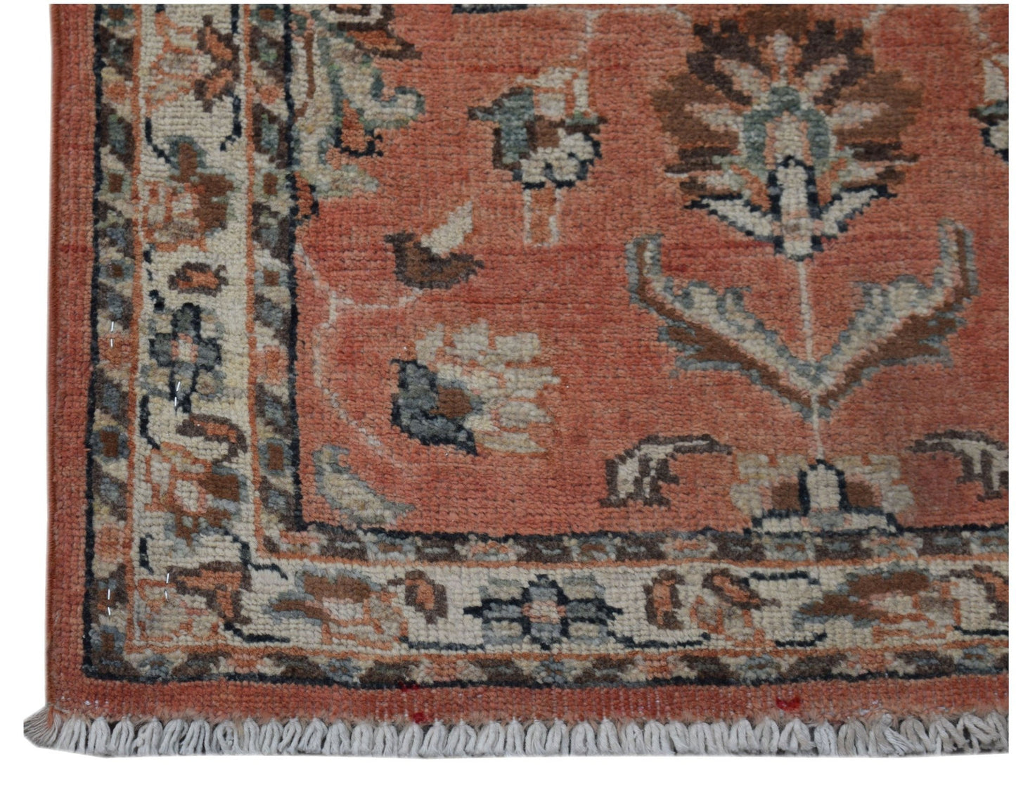 A handmade Afghan Chobi rug featuring a floral pattern in shades of terracotta, cream, and blue.
