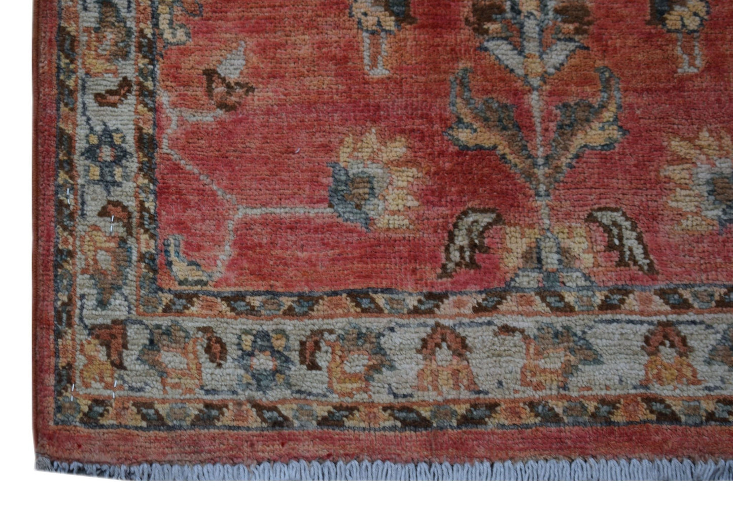 A handmade Afghan Chobi rug featuring a floral pattern in shades of red, beige, and blue.