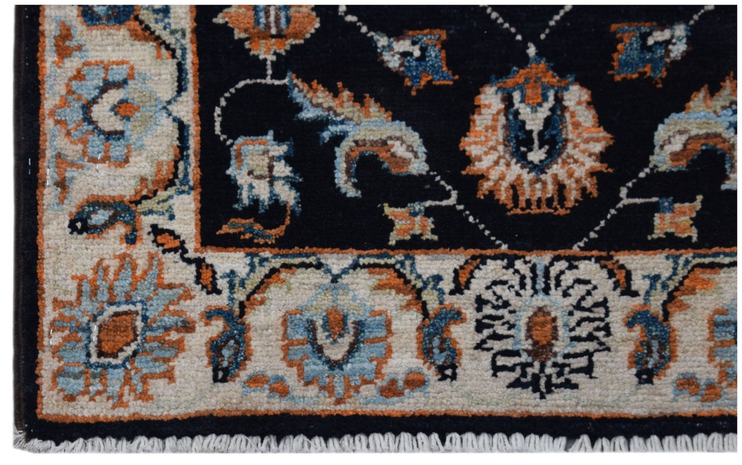 A handmade Afghan Chobi rug featuring a black field with intricate floral patterns and a cream border.