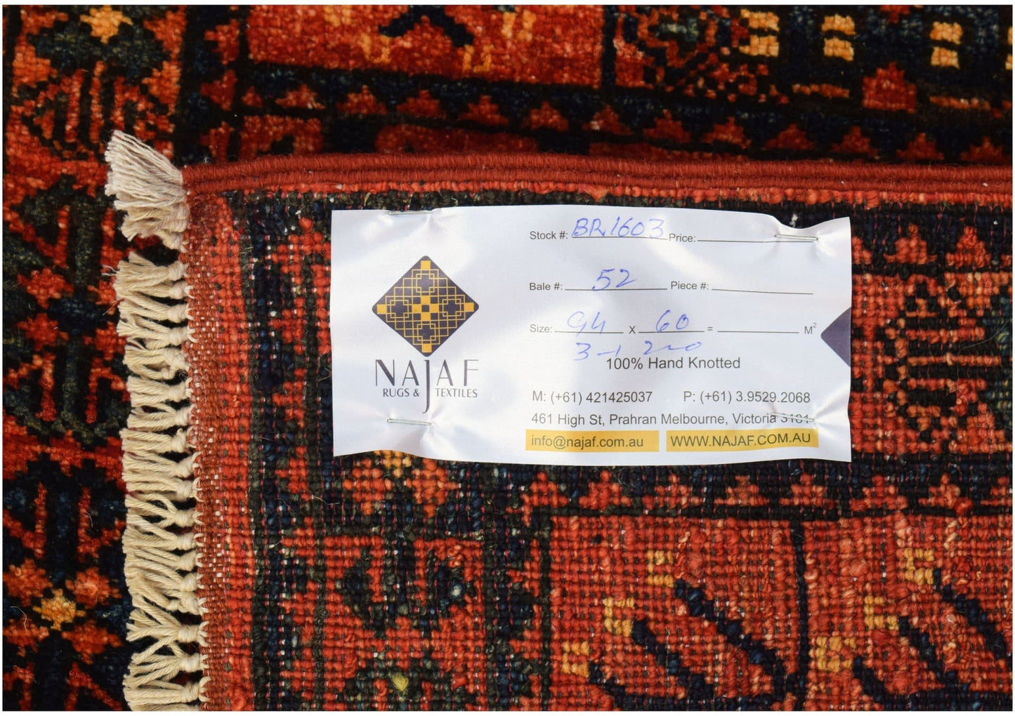 A handmade Afghan Chobi rug featuring a traditional geometric pattern in red and dark blue.