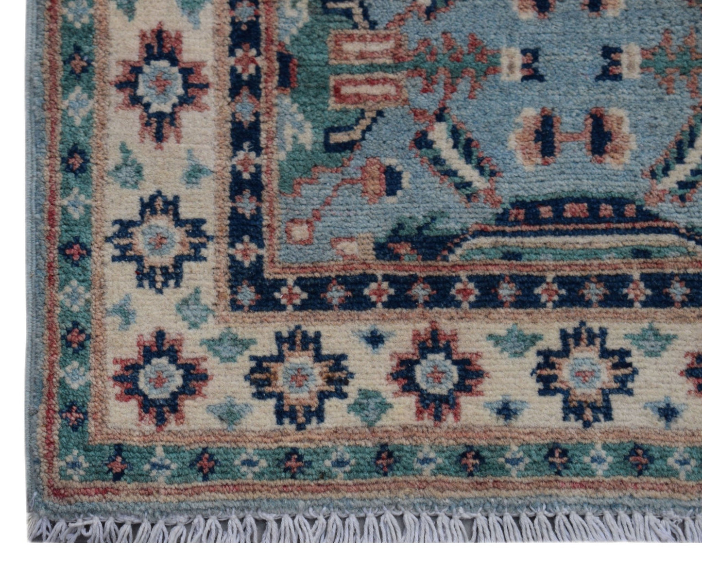 A handmade wool Afghan Kazakh rug featuring a geometric pattern in blue, cream, and red tones.
