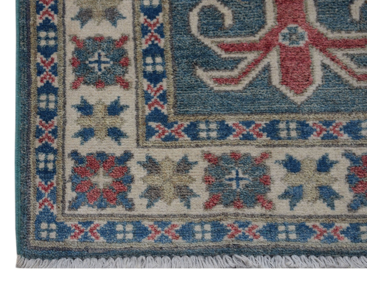 A handmade wool Afghan Kazakh rug featuring a geometric pattern in blue, red, and cream tones.