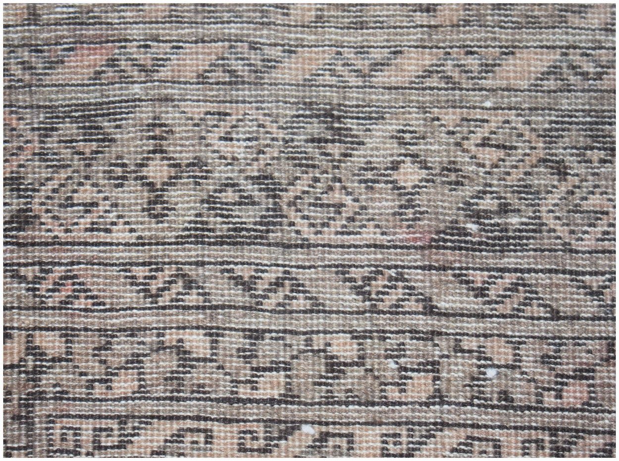 A vintage Afghan Turkmen rug featuring intricate geometric patterns in muted brown and tan tones.