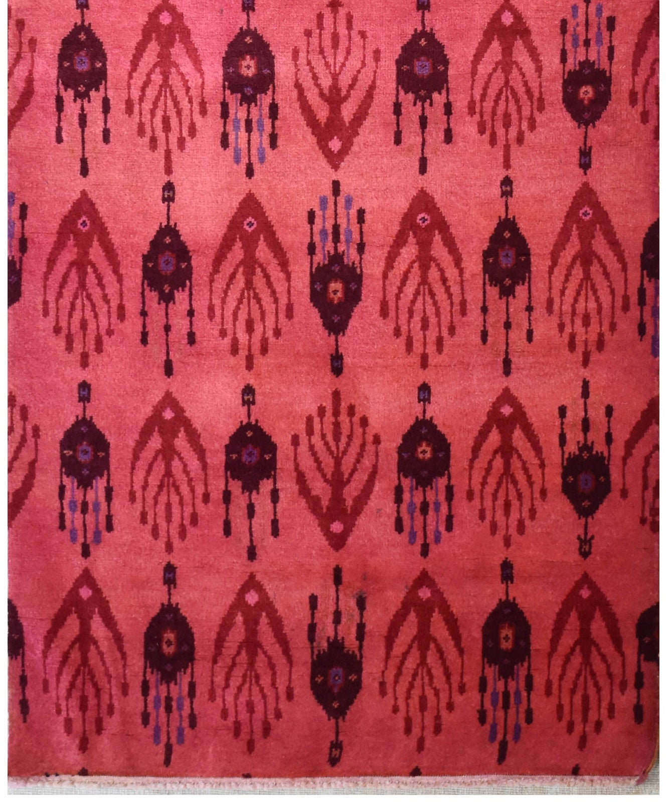 Handmade Afghan wool runner featuring a repeating ikat-style pattern in shades of red and purple.