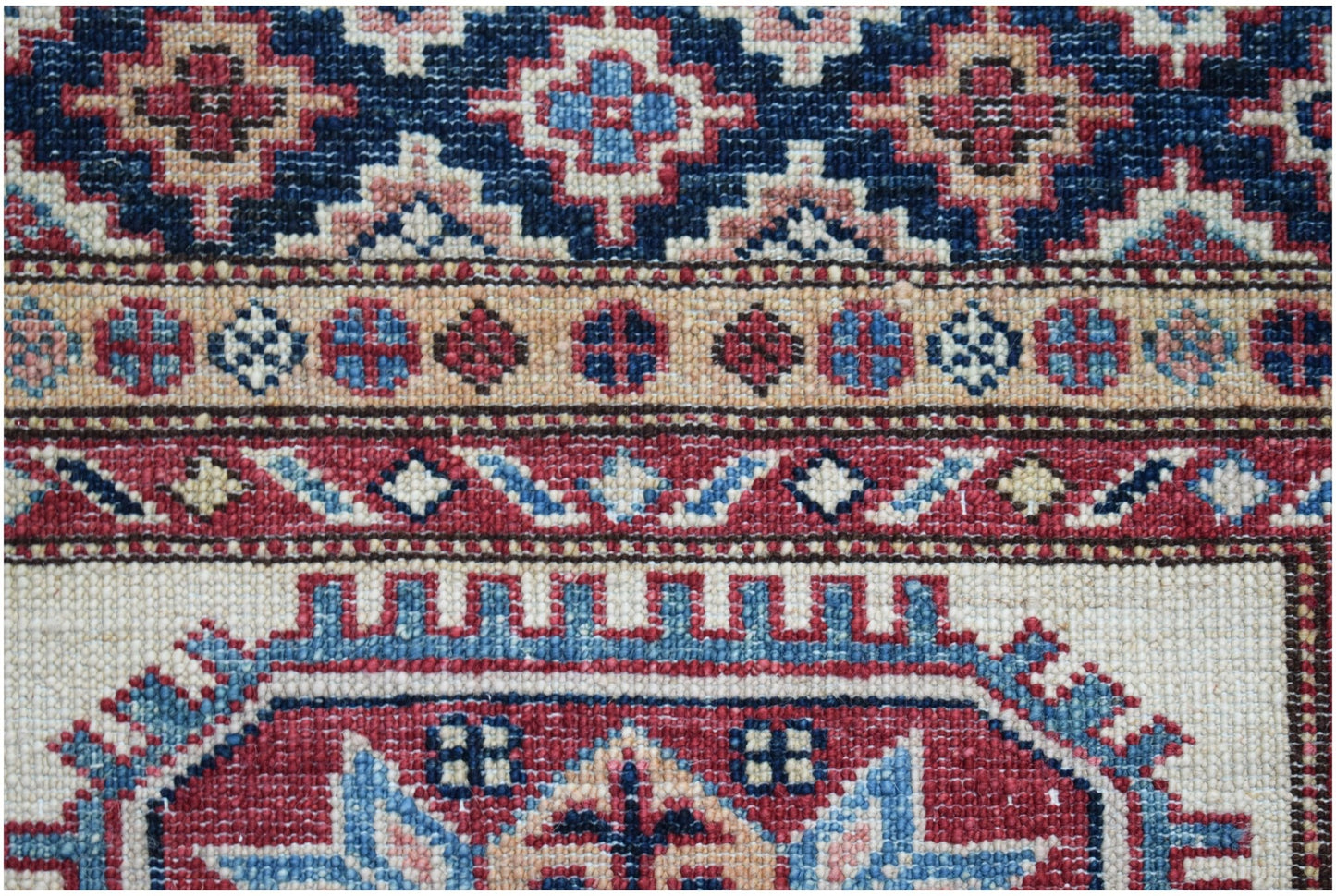 A close-up of an Afghan Super Kazakh runner featuring intricate geometric patterns in wool.