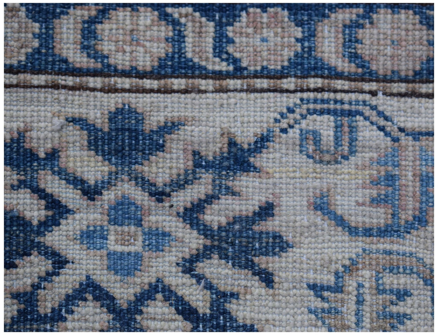 A close-up of an Afghan Super Kazakh rug featuring traditional blue and cream geometric patterns.