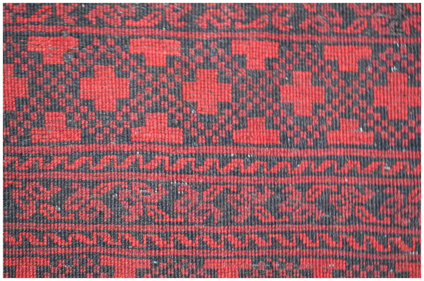 Vintage Afghan Turkmen rug with red and black geometric patterns.