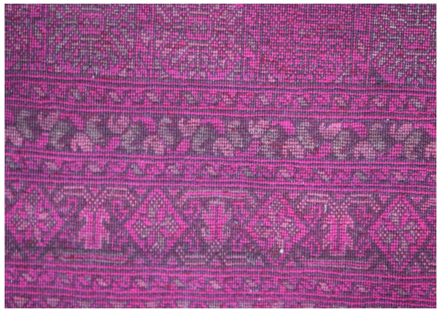 A vintage Afghan Turkmen rug featuring intricate geometric patterns in shades of pink and brown.