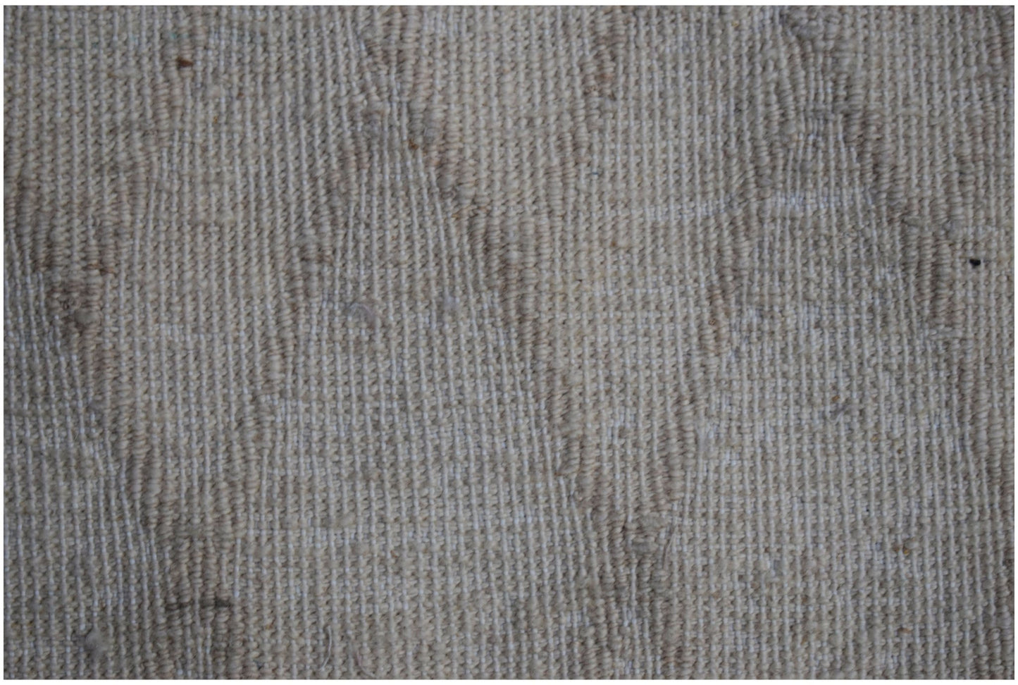 A close-up view of a handmade Afghan Yekta rug featuring a textured, neutral-toned wool weave.