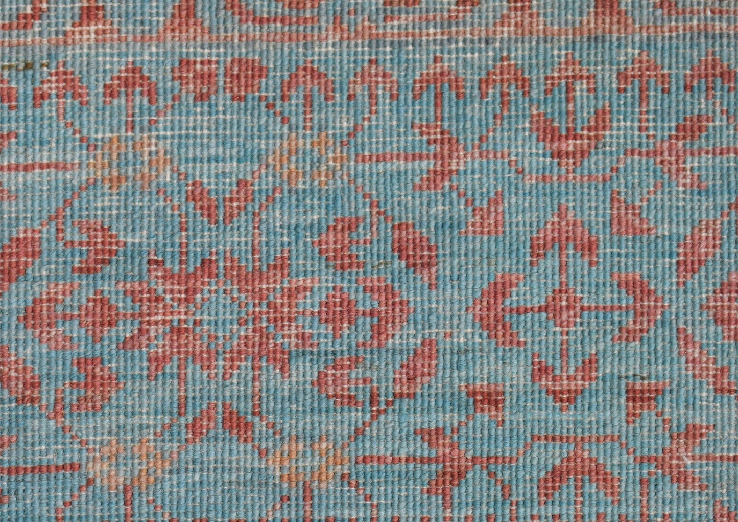 A close-up of a handwoven Afghan Chobi rug featuring a detailed Mamluk pattern in blue and red.
