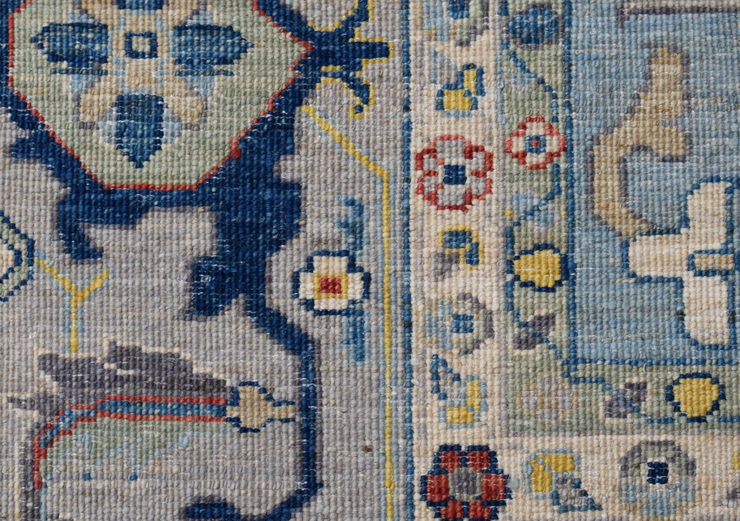 A close-up of a handwoven transitional Oushak rug featuring intricate floral patterns in blue.