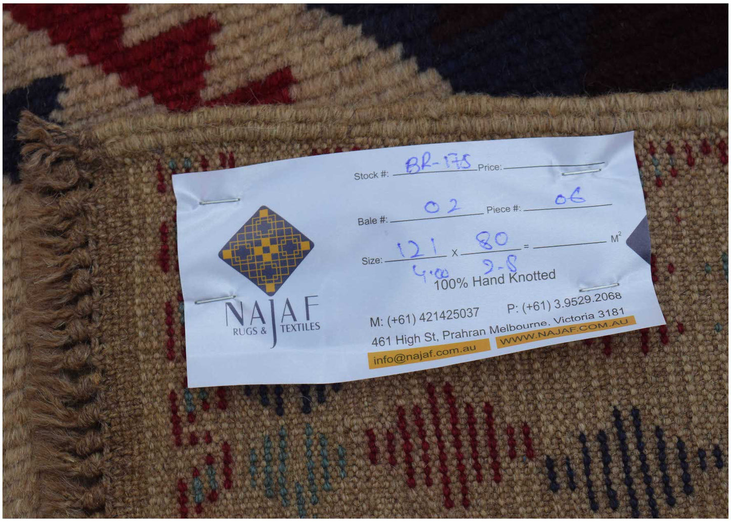 A handmade Afghan Pashm rug featuring a tribal pattern in dark red, brown, and blue tones.