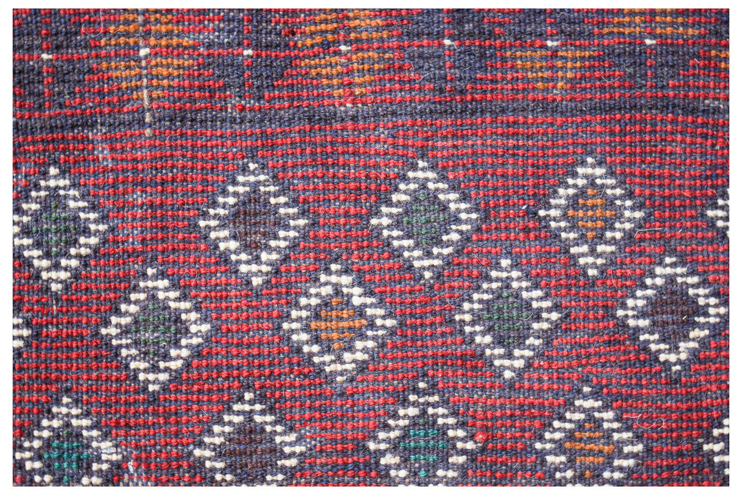 Handmade Afghan Pashm rug featuring a geometric diamond pattern in red, blue, and ivory wool.