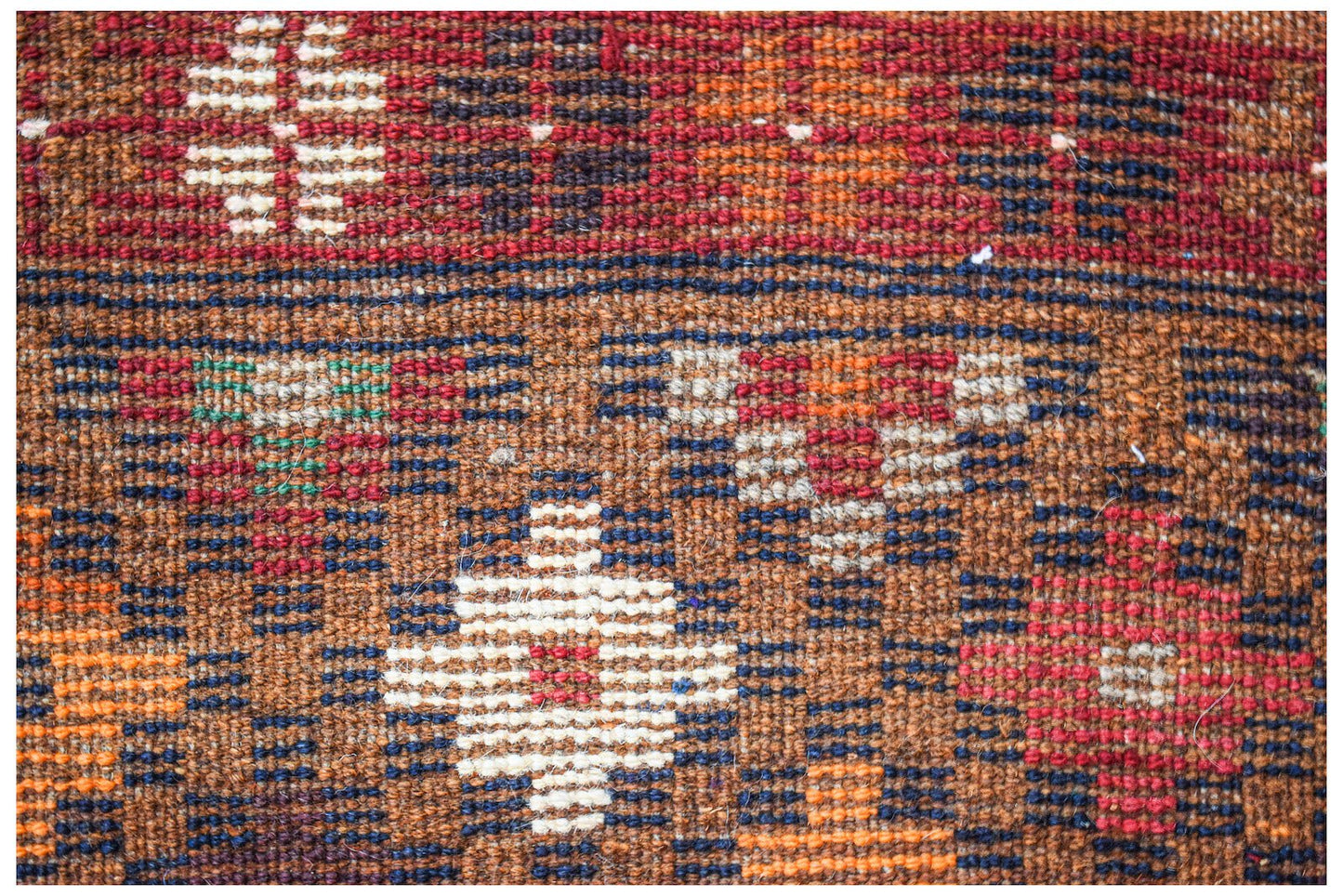 A handmade Afghan Pashm rug featuring a geometric tribal pattern in shades of red, brown, and ivory.