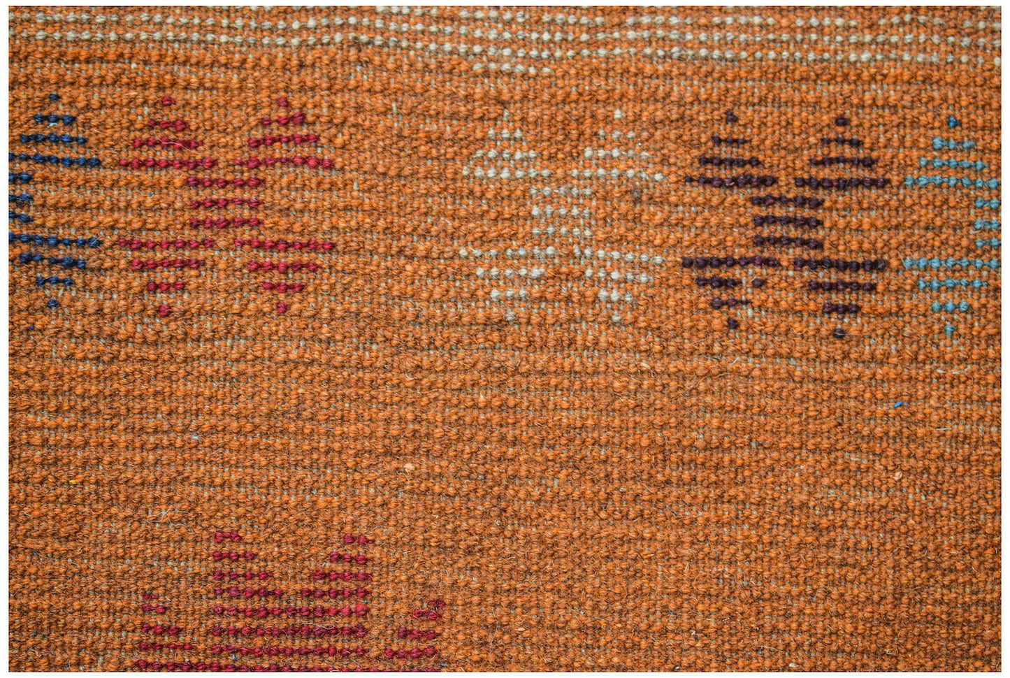 Handmade Afghan Pashm rug featuring a textured orange wool base with geometric tribal patterns.