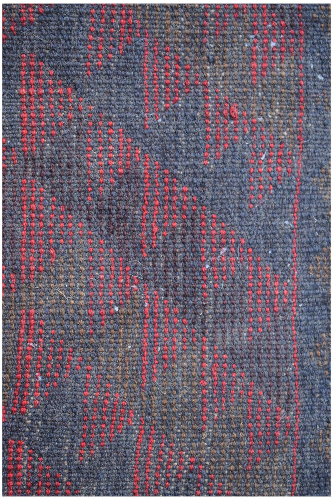 Handmade Afghan Pashm rug featuring a tribal pattern in dark red, brown, and blue wool.