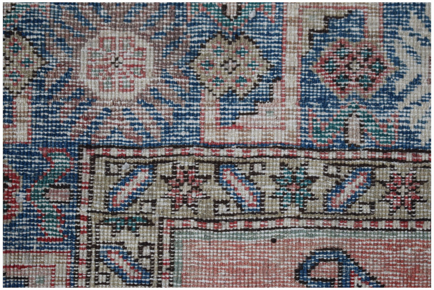 A vintage handmade Caucasian wool rug featuring a traditional geometric pattern in vibrant colors.