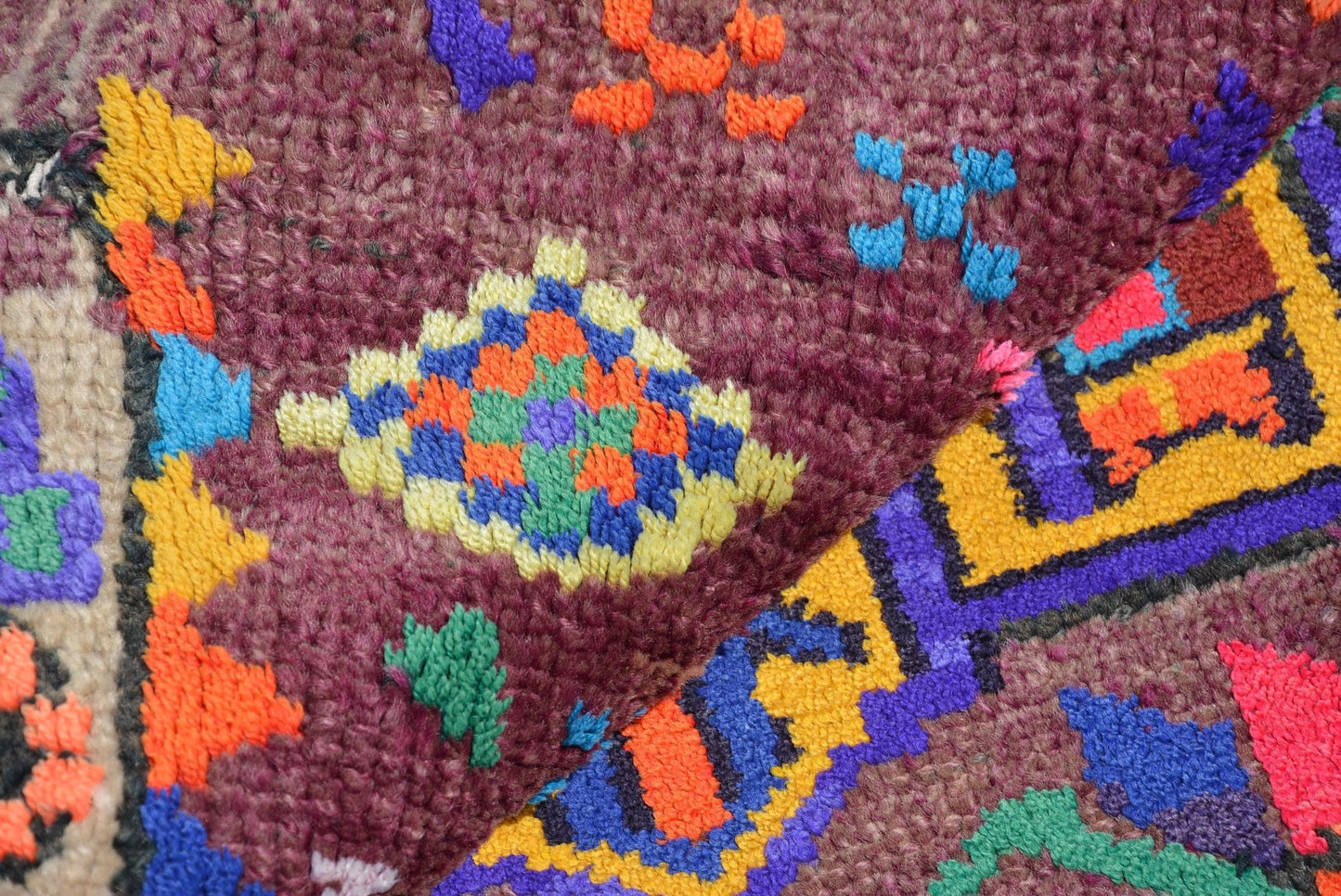 Vintage Kurdish Herki runner with colorful tribal motifs on a purple background.