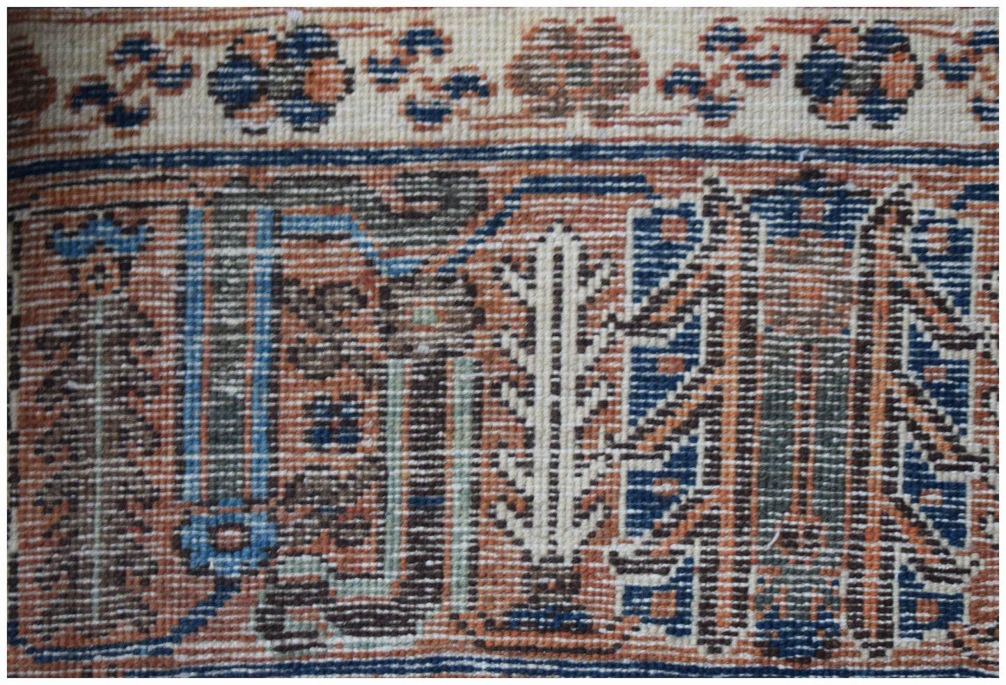A close-up of a vintage Persian Ghashghai rug featuring intricate geometric and floral patterns.