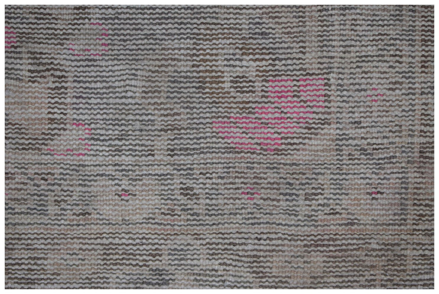 A vintage Persian runner featuring a faded, handwoven pattern with muted tones and pink accents.