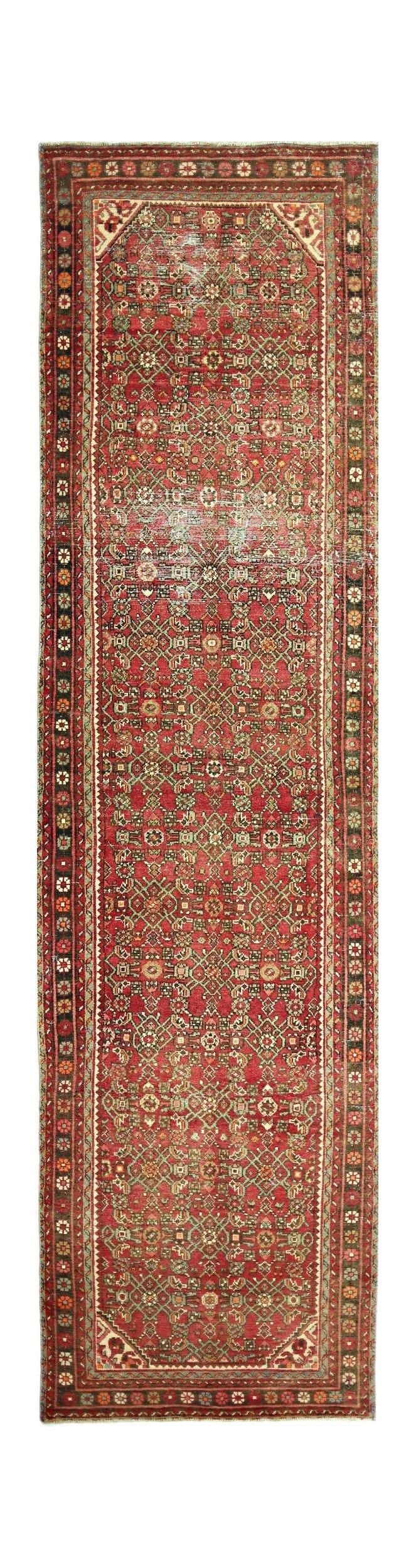 A vintage Persian Hamadan runner rug featuring a geometric red pattern with green accents.