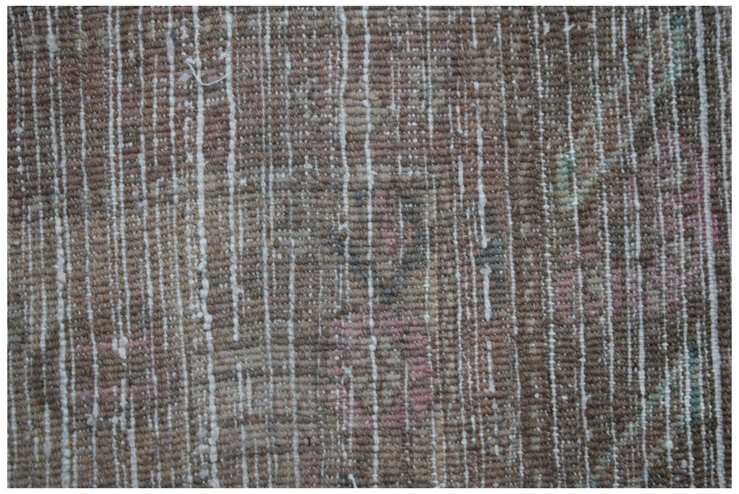 A close-up view of a vintage Persian Hamadan rug featuring a worn, textured wool pile.