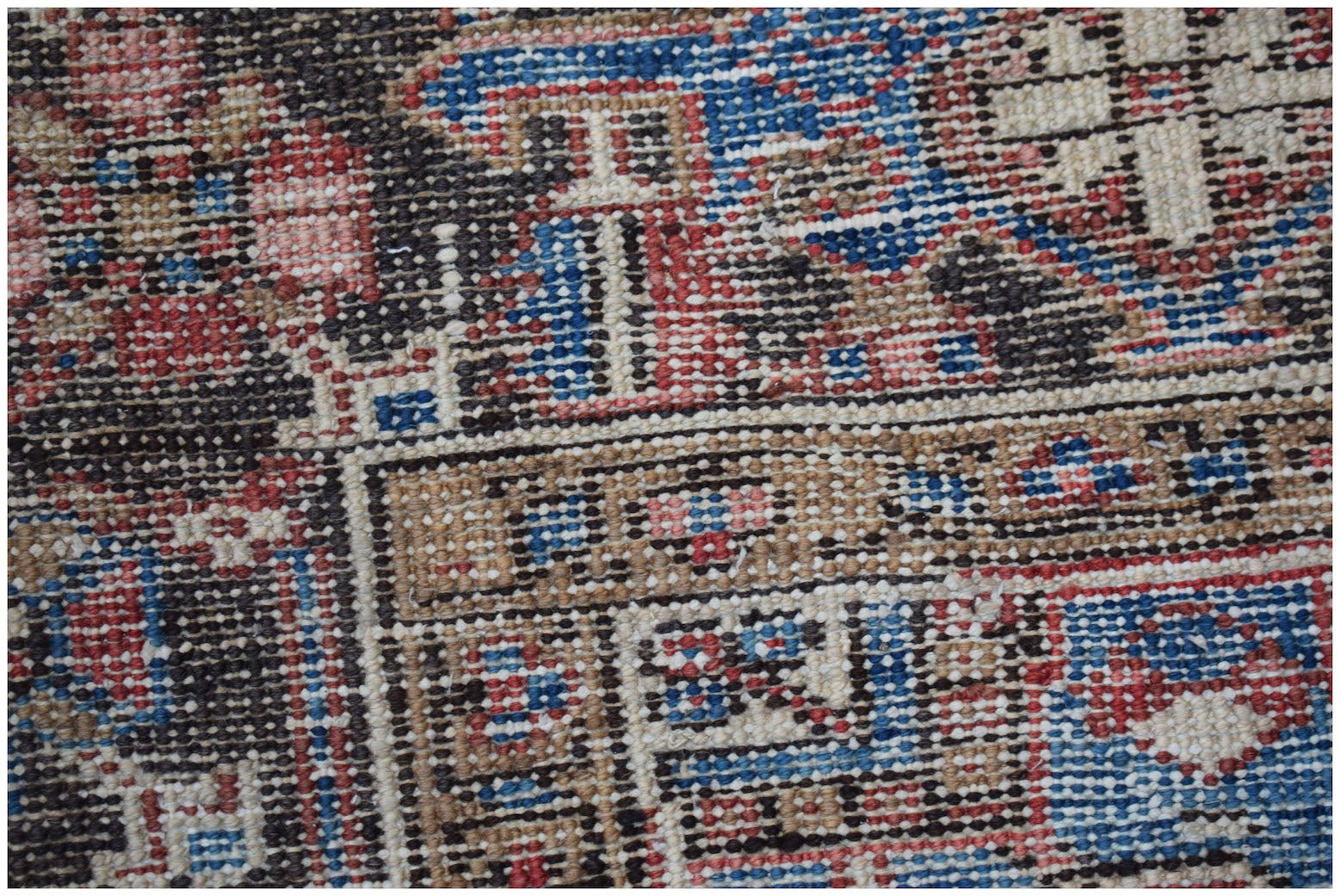 A close-up view of a handwoven vintage Persian Heriz rug featuring intricate geometric patterns.